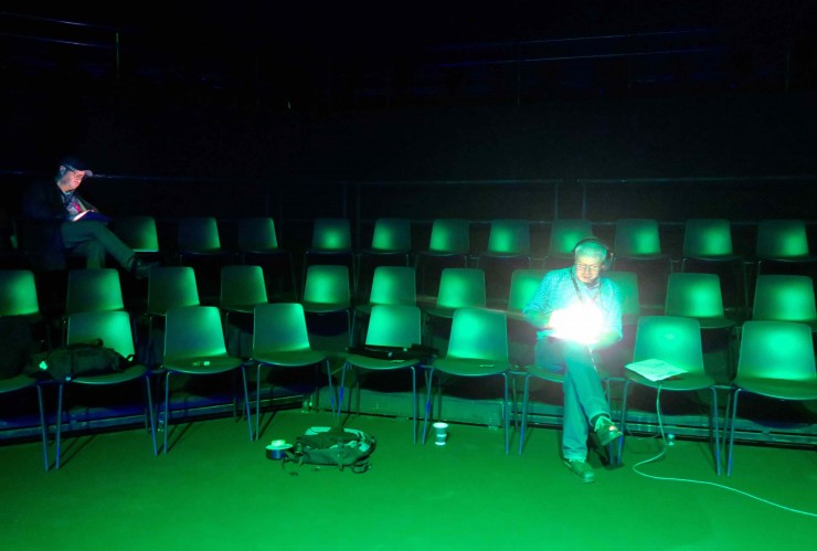 Man in green light in an auditorium
