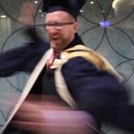 Man in academic dress spins