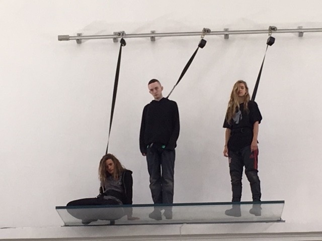 Three people on a glass platform up high